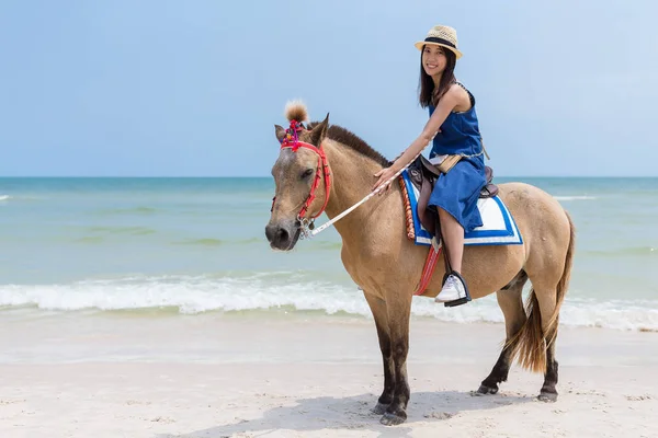 Frau reitet Pferd in Sandstrand — Stockfoto