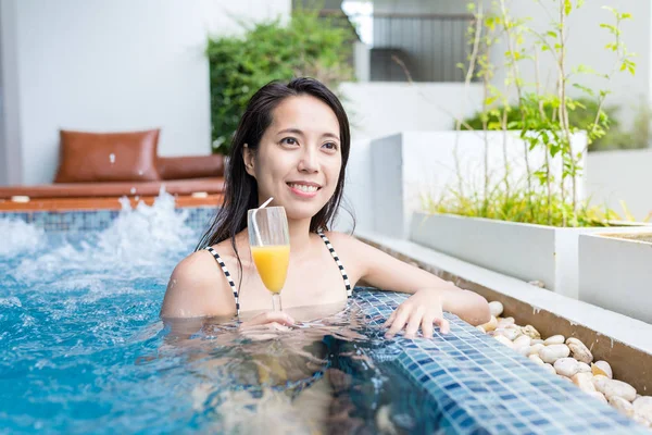 Жінка насолоджується своїм напоєм у басейні — стокове фото