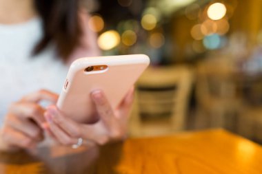 kahve dükkanında cep telefonu kullanan kadın