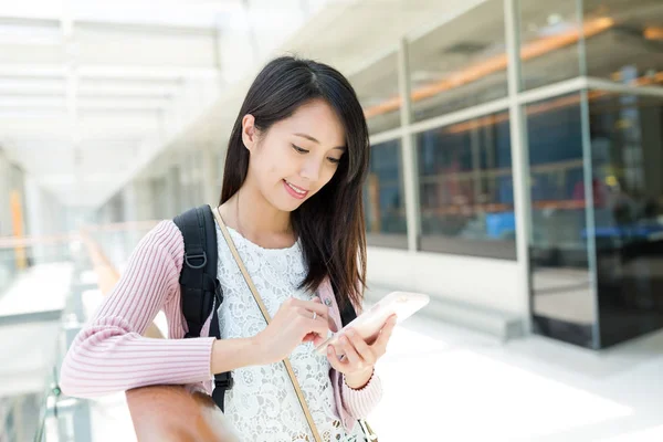 Vrouw met mobiele telefoon in het winkelcentrum — Stockfoto