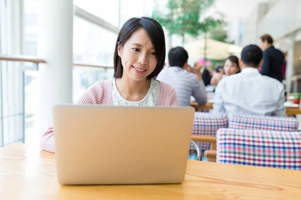 Woman working on notebook computer in coffee shop — Stock Photo, Image