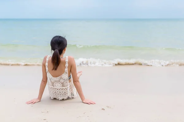 Žena sedí na písečné pláži — Stock fotografie