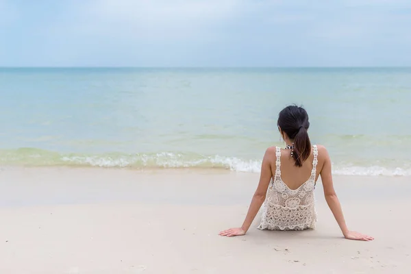 Mulher jovem relaxante na praia de areia — Fotografia de Stock