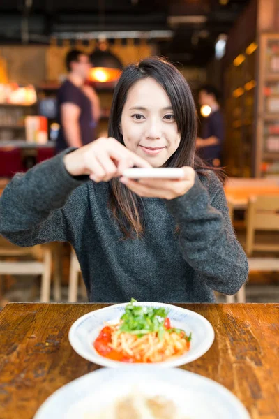 Donna che scatta foto sui suoi piatti nel ristorante — Foto Stock