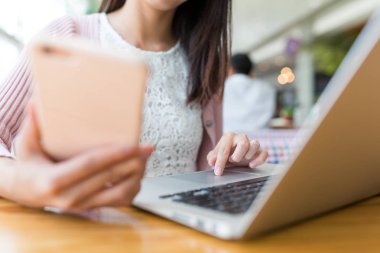 cep telefonu ve dizüstü bilgisayar kullanan kadın