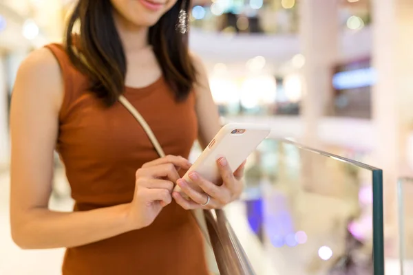 Женщина, использующая мобильный телефон внутри торгового центра — стоковое фото