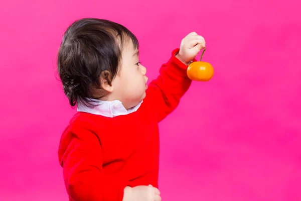 Kinesiska lilla bebis tittar på citrus — Stockfoto