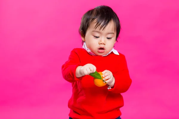 Asiatiska liten pojke håller en tangerine — Stockfoto