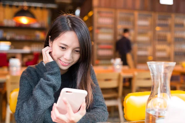 Женщина, использующая мобильный телефон в ресторане — стоковое фото