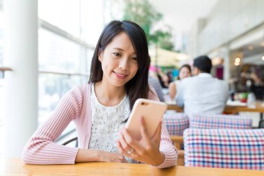 Restoran cep telefonu bakarak kadın