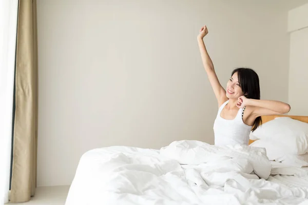 Mulher se alongando em sua cama — Fotografia de Stock