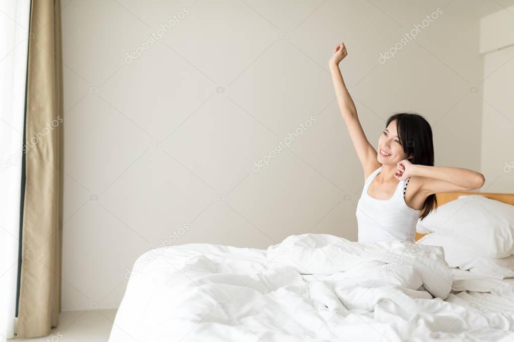 Woman Stretching in Her Bed