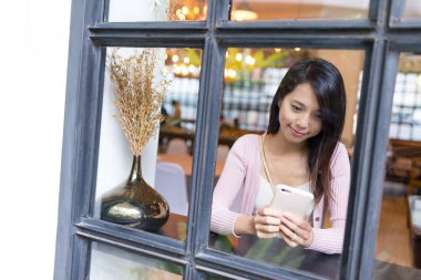 Cep telefonuyla restoranda pencere