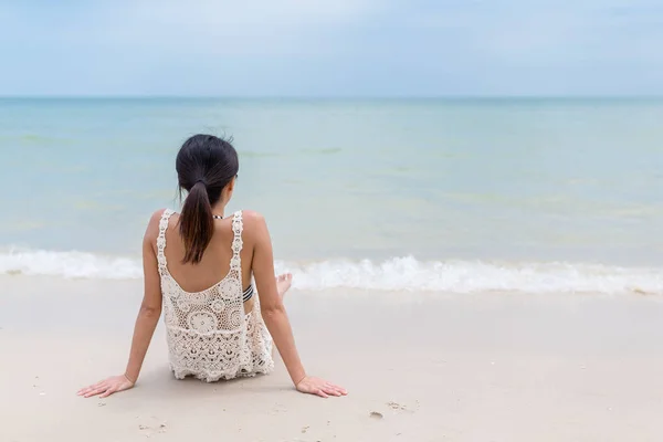 Mulher sentada na praia de areia — Fotografia de Stock