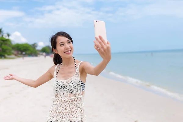 Kobieta, biorąc selfie przez telefon komórkowy na plaży — Zdjęcie stockowe