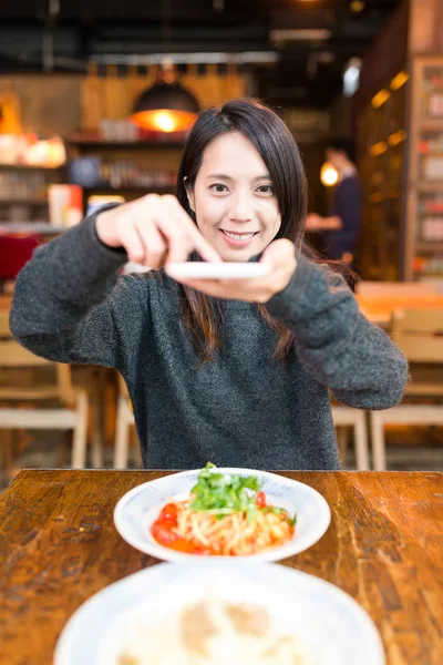 Woman taking photo on her dishes in restaurant — Stock Photo, Image