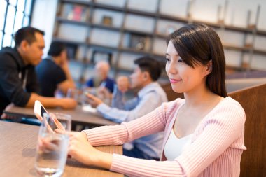 Cep telefonunu restoranda çalışan kadın