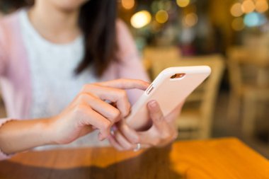 kahve dükkanında cep telefonu kullanan kadın