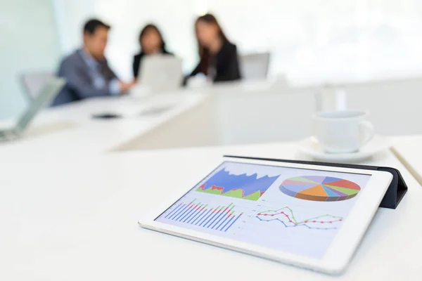 Digital tablet showing graph with business partners discussing — Stock Photo, Image