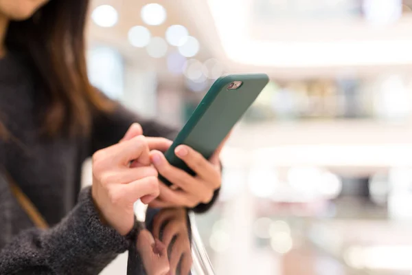 Vrouw met mobiele telefoon in het winkelcentrum — Stockfoto