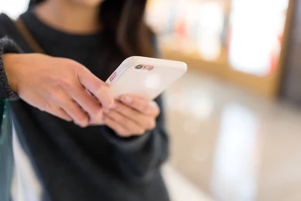 Vrouw met behulp van de mobiele telefoon naar online — Stockfoto