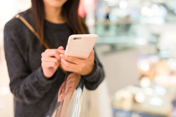 Жінка використовує мобільний телефон у торговому центрі — стокове фото