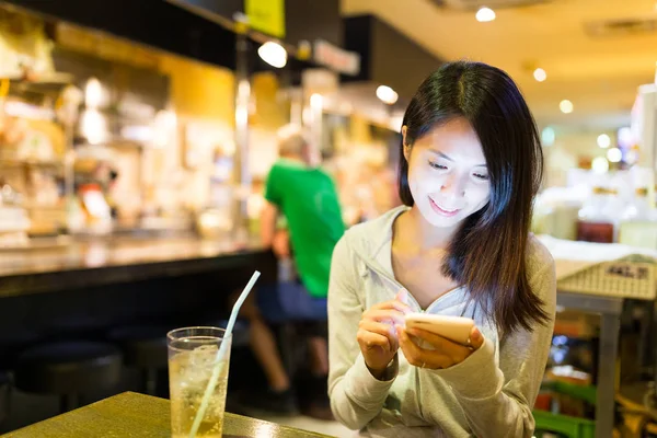 Жінка, що використання мобільного телефону у японський ресторан — стокове фото