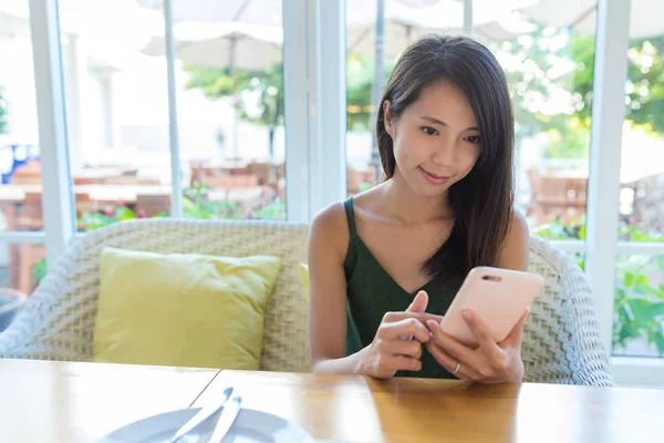 Женщина, использующая мобильный телефон в кафе — стоковое фото