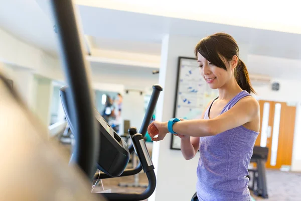 Formation de femme sur la machine elliptique et l'utilisation de la montre intelligente — Photo