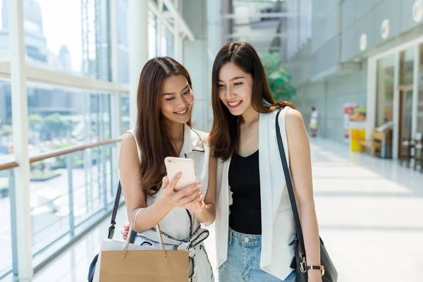 Vrouwen winkelen en kijken naar smartphone texting — Stockfoto