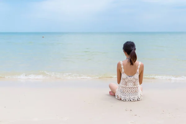 Mujer sentada en la playa — Foto de Stock