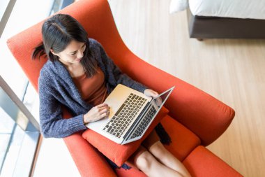 evde dizüstü bilgisayar üzerinde çalışan kadın