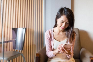 kahve dükkanında cep telefonu kullanan kadın