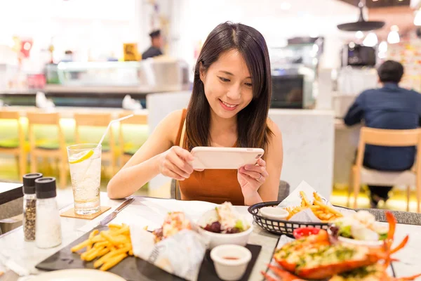 Frau fotografiert Geschirr in Restaurant — Stockfoto