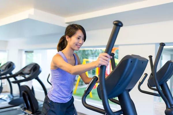 Young Woman training on Elliptical machine
