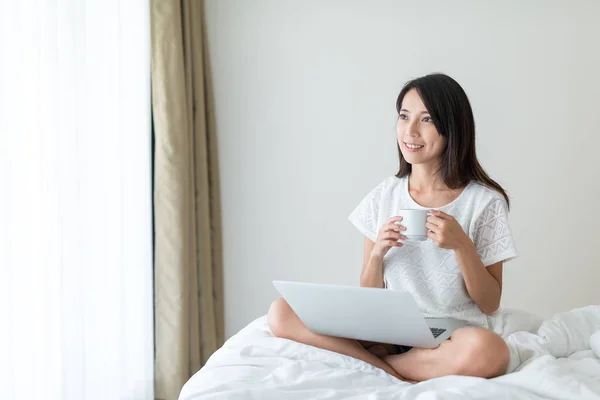 Žena pracuje na notebooku a vychutnat si kávu — Stock fotografie