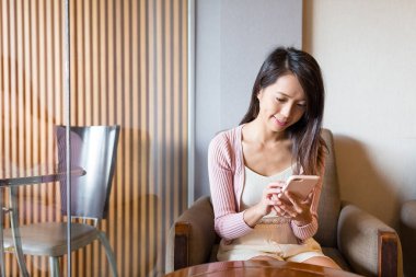 Kahve dükkanında cep telefonu kullanan kadın