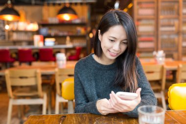 restoranda cep telefonu kullanan kadın