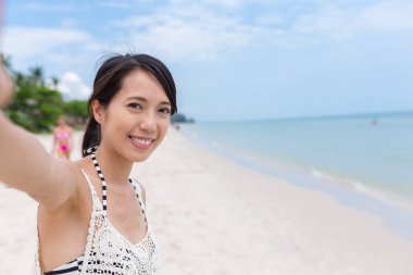 Selfie Beach'te çekmek için kamera tutan kadın