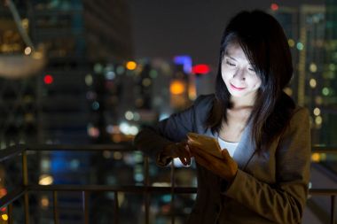 Businesswoman using mobile phone at night