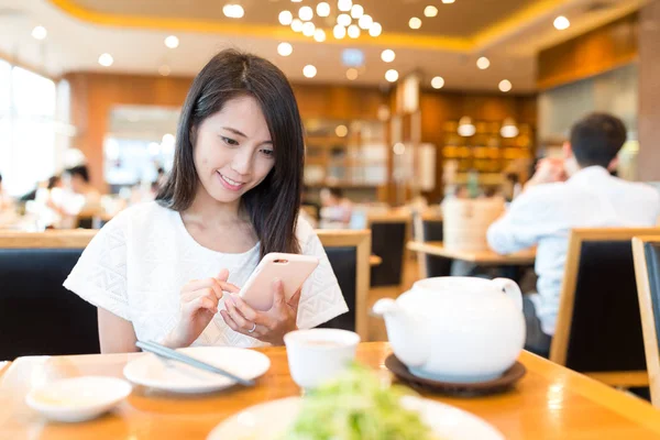 Mulher usando celular no restaurante chinês — Fotografia de Stock