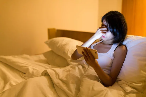 Mulher sentindo-se cansada com o uso de noite cellphoneat — Fotografia de Stock