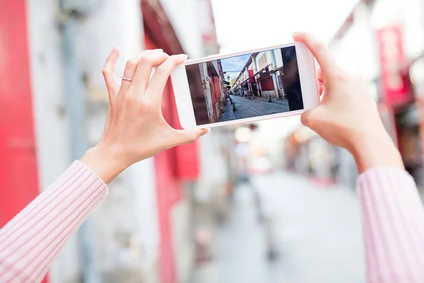 Vrouw nemen foto op cellphone in Macau — Stockfoto