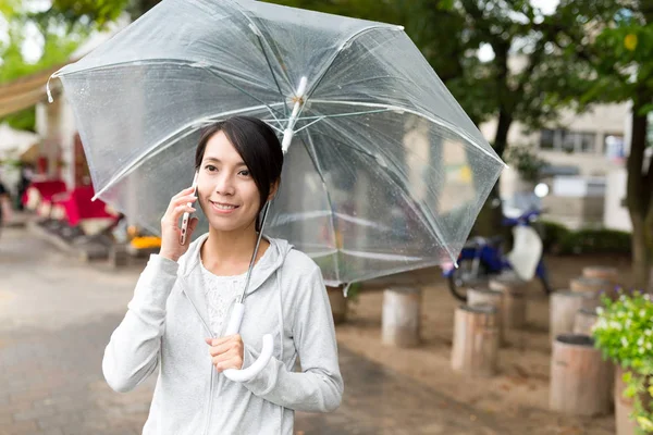 Femme parlant sur téléphone portable avec parapluie — Photo
