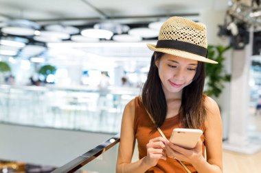 Alışveriş merkezinde cep telefonu kullanan kadın