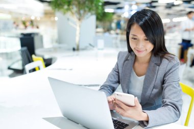 Birlikte laptop ve cep telefonu kullanan kadın