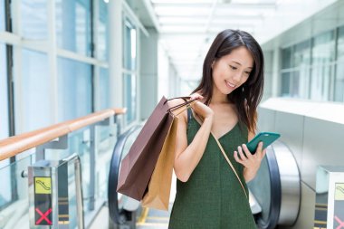 Kadın alışveriş çantası ve cep telefonu kullanarak taşımak