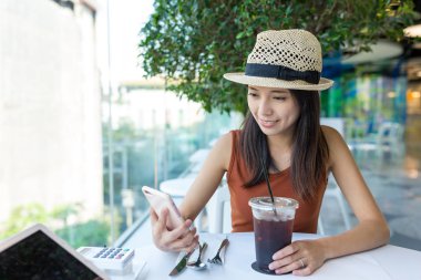 Kahve dükkanında cep telefonu kullanan kadın