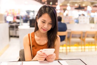 kahve dükkanında cep telefonu kullanan kadın