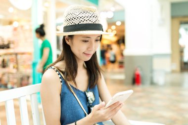 Alışveriş merkezinde cep telefonu kullanan kadın